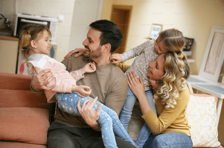 Parents with two kids in a new home, representing the flexibility of a Buy Now Sell Later mortgage